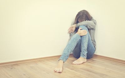 不快乐的女孩坐在角落里