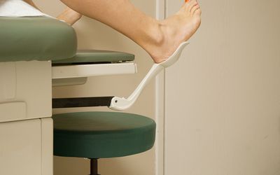 女人在妇科医生办公室里把脚踩得高高的