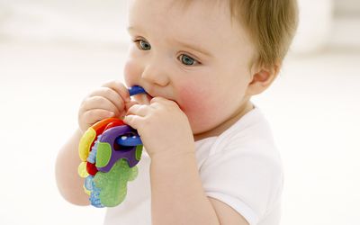 Baby boy chewing on teething ring
