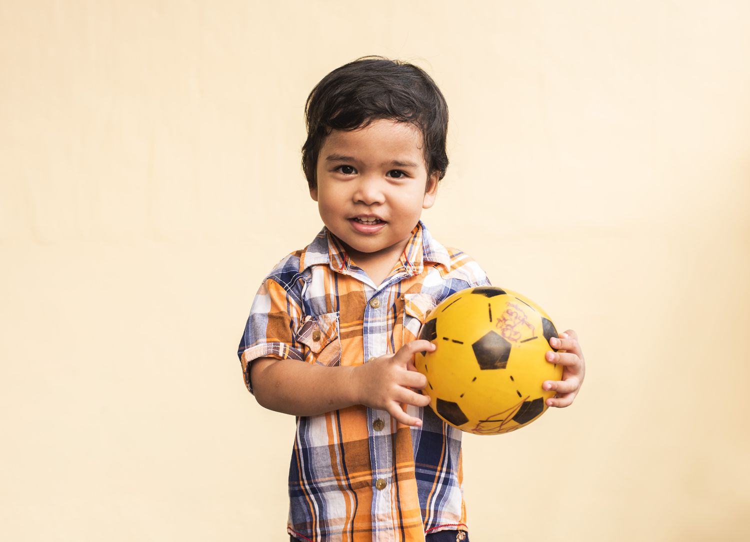 Toddler boy holding a ball