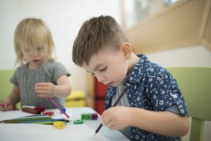 Toddler brother and sister drawing with colored pencils