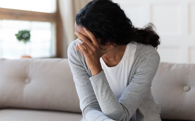 Unhappy biracial woman look in distance feeling depressed