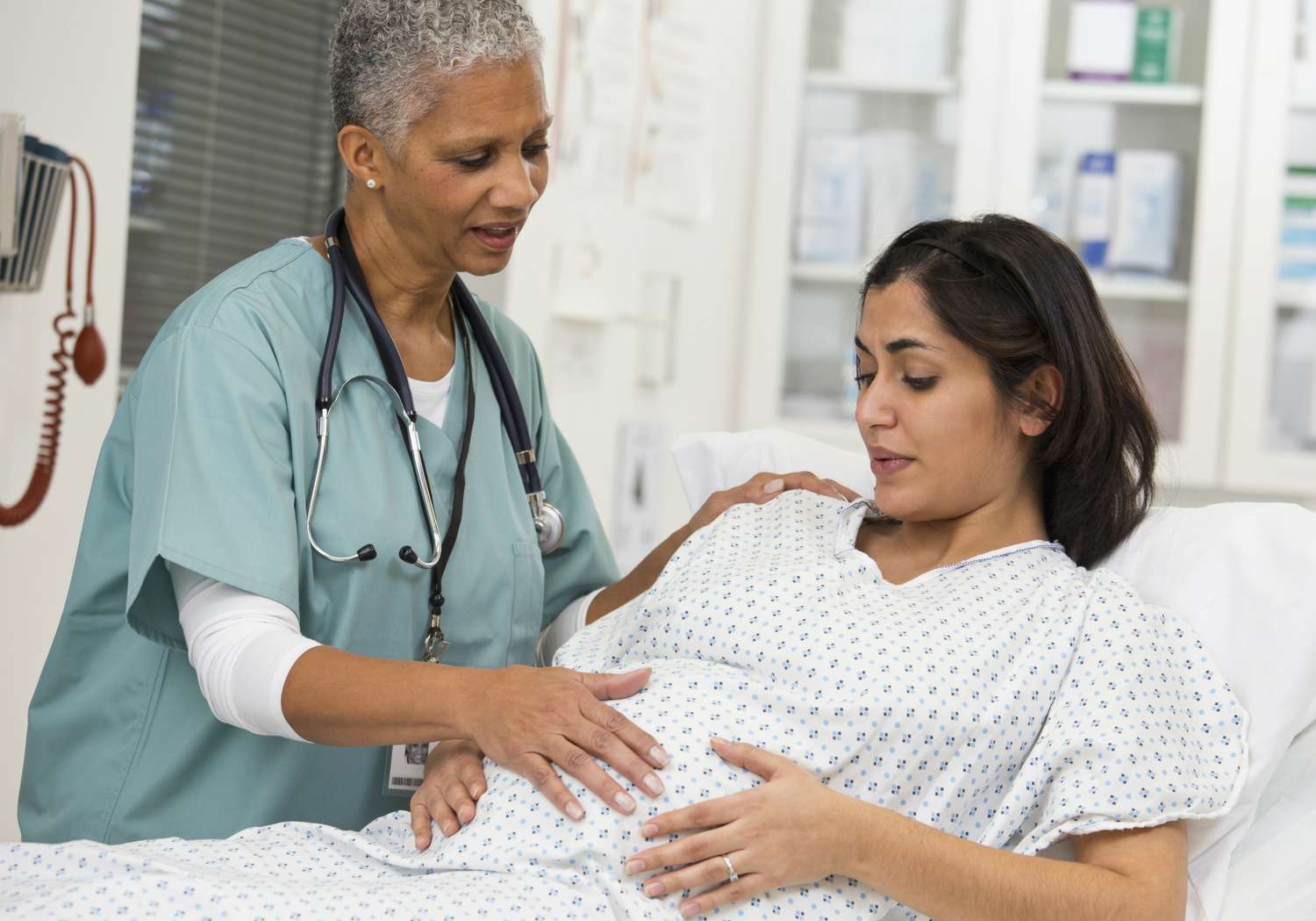 Doctor examining pregnant patient's belly