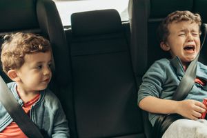 Twins in the car, one is crying