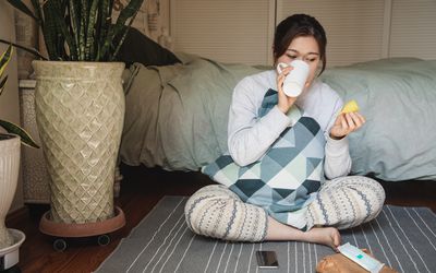 一名女子在卧室里拿着月经杯喝水