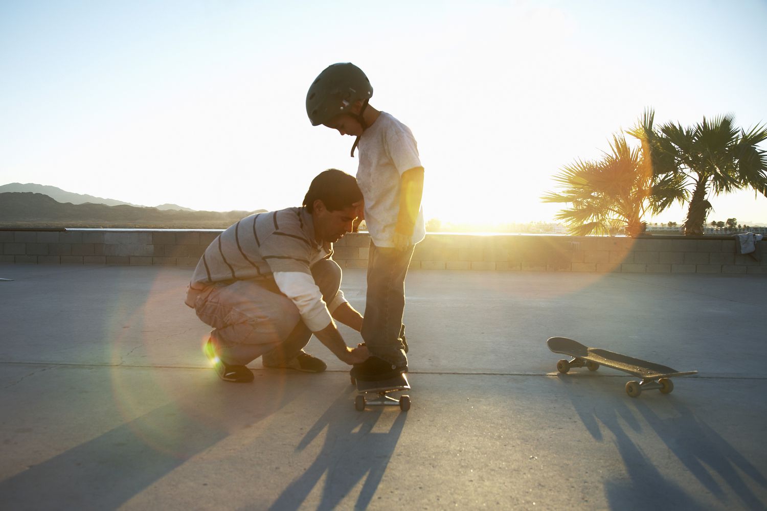 Father teaching son (10-11) skateboard