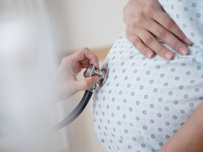 Stethoscope against pregnant woman's stomach