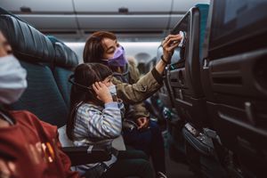 妈妈在飞机上为孩子消毒电视屏幕