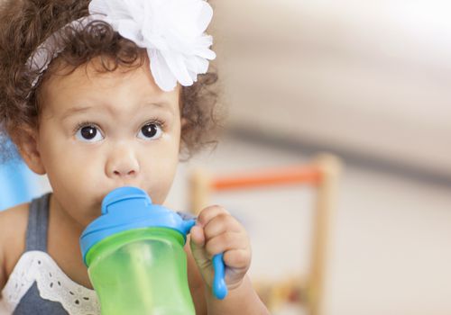 Baby girl drinking from sippy cup
