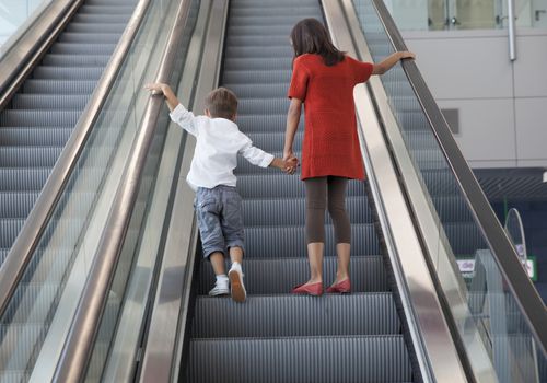 Boy and girl standing on escalator.