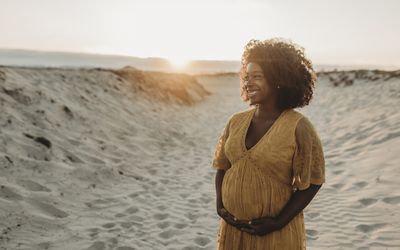 Pregnant Black woman holding her baby bump