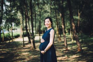 穿着礼服的女人抱着怀孕的肚子