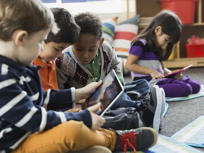 Young children play on digital tablets in school.