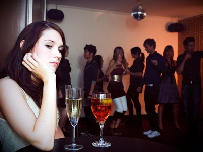 young woman is sitting alone in a nightclub