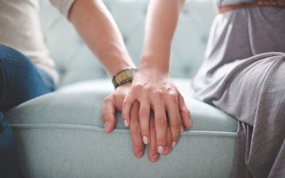 一张男女手牵手坐在沙发上的腰照