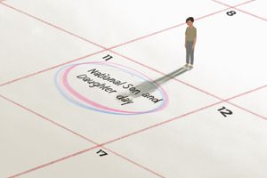 一个孩子站在日历上的插图，上面用粉色和蓝色圈出了“全国儿女日”