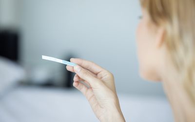 妇女拿着验孕棒，裁剪华体会体育官方人口