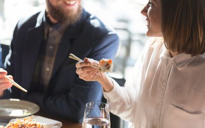 Couple eating sushi and smiling