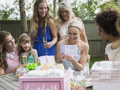 Pregnant woman reading card at backyard baby shower
