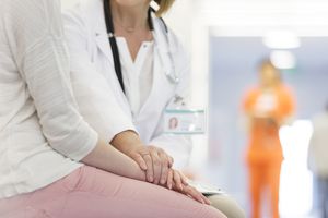 Doctor comforting patient in corridor