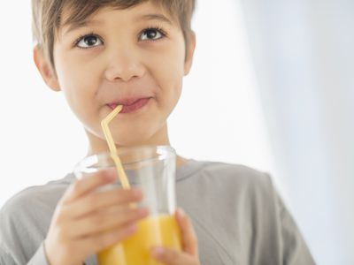 young boy drinking juice with straw