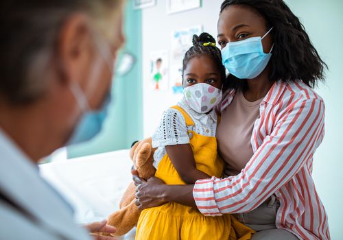 Mom and child wearing masks at pediatrician's office