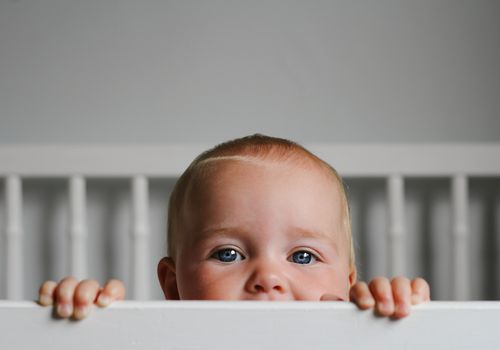 Baby peeking out of crib