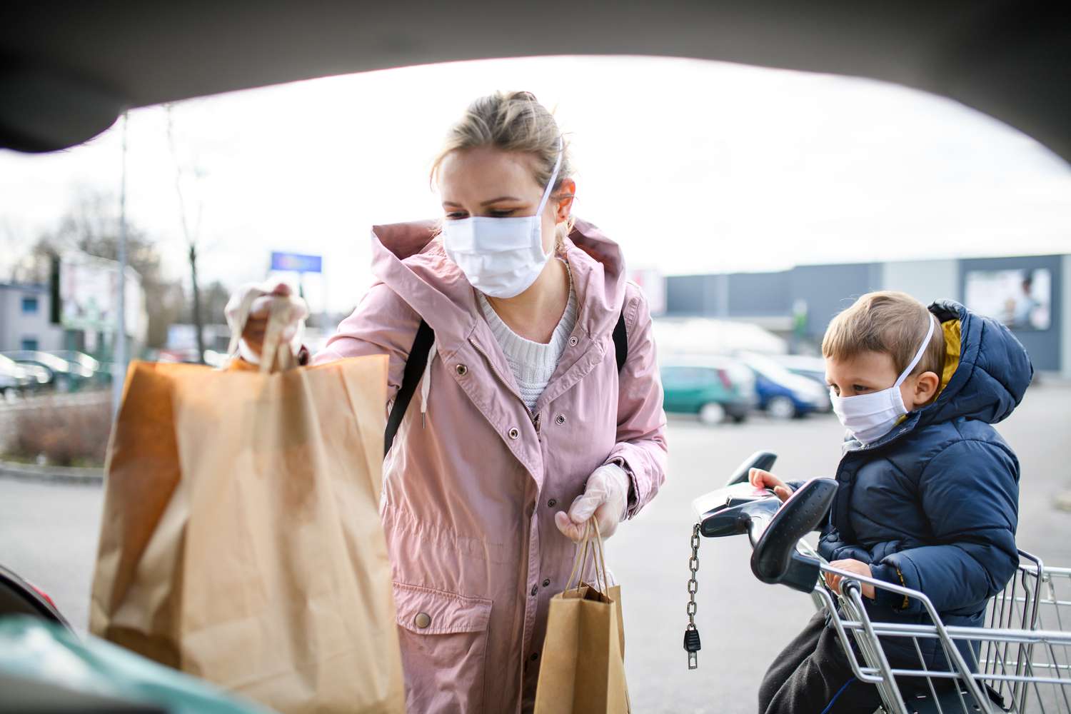 mom and son putting groceries in the car