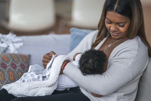 Woman nursing baby at home