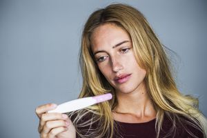 年轻女子失望地看着验孕棒华体会体育官方人口