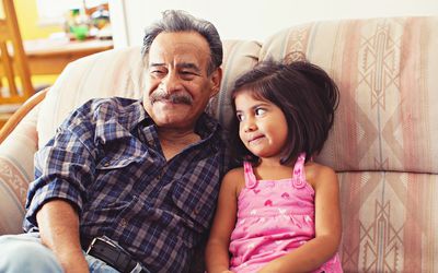 Grandfather and Granddaughter Laughing on Couch