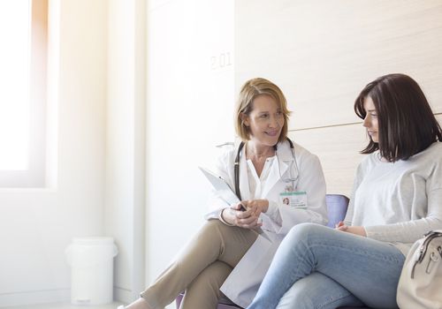 Doctor and patient reviewing medical record in clinic lobby