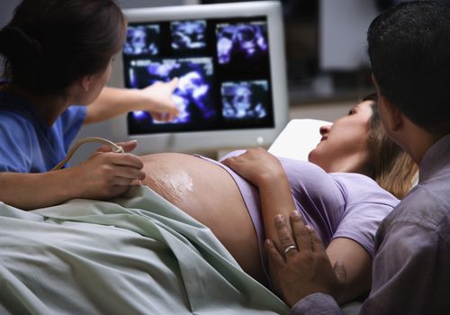 女医生指着孕妇的超声波照片