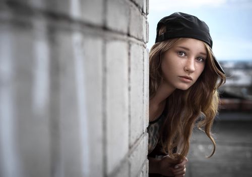 girl peeking around a corner