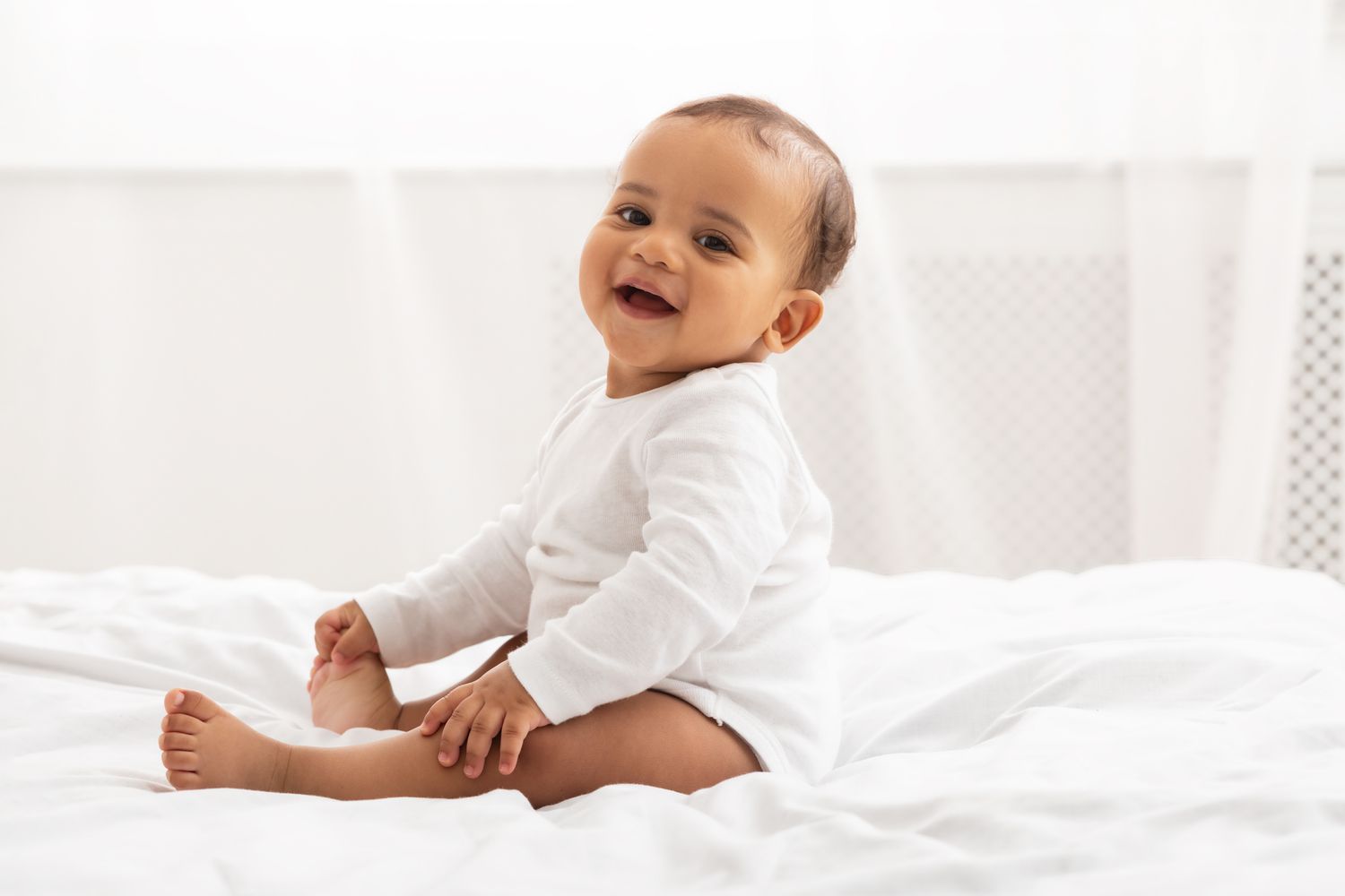 Baby sitting on bed