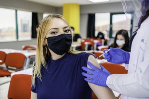 teen girl getting a vaccine shot from a nurse