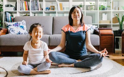 Woman doing yoga with her daughter