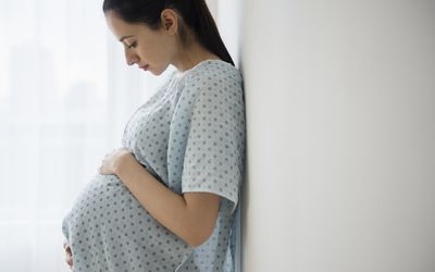 Pregnant woman holding her belly in hospital