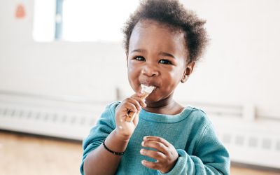 Toddler eating yogurt