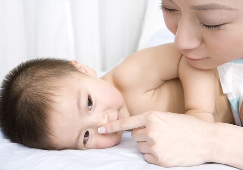 Mother and baby boy on bed