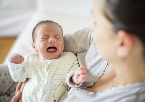 mother holding crying baby