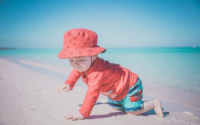 小男孩在古巴可可岛热带海滩上爬行