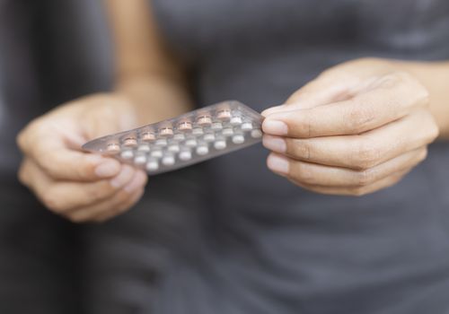 女人拿着一袋避孕药