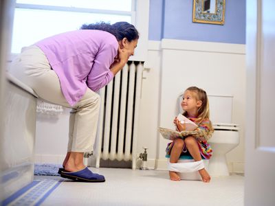Girl reading a book on a potty chair