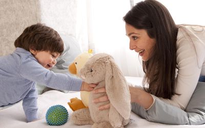 Mom and toddler boy playing with stuffed animals