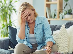 年轻女子在家里验孕，看起来很担心华体会体育官方人口