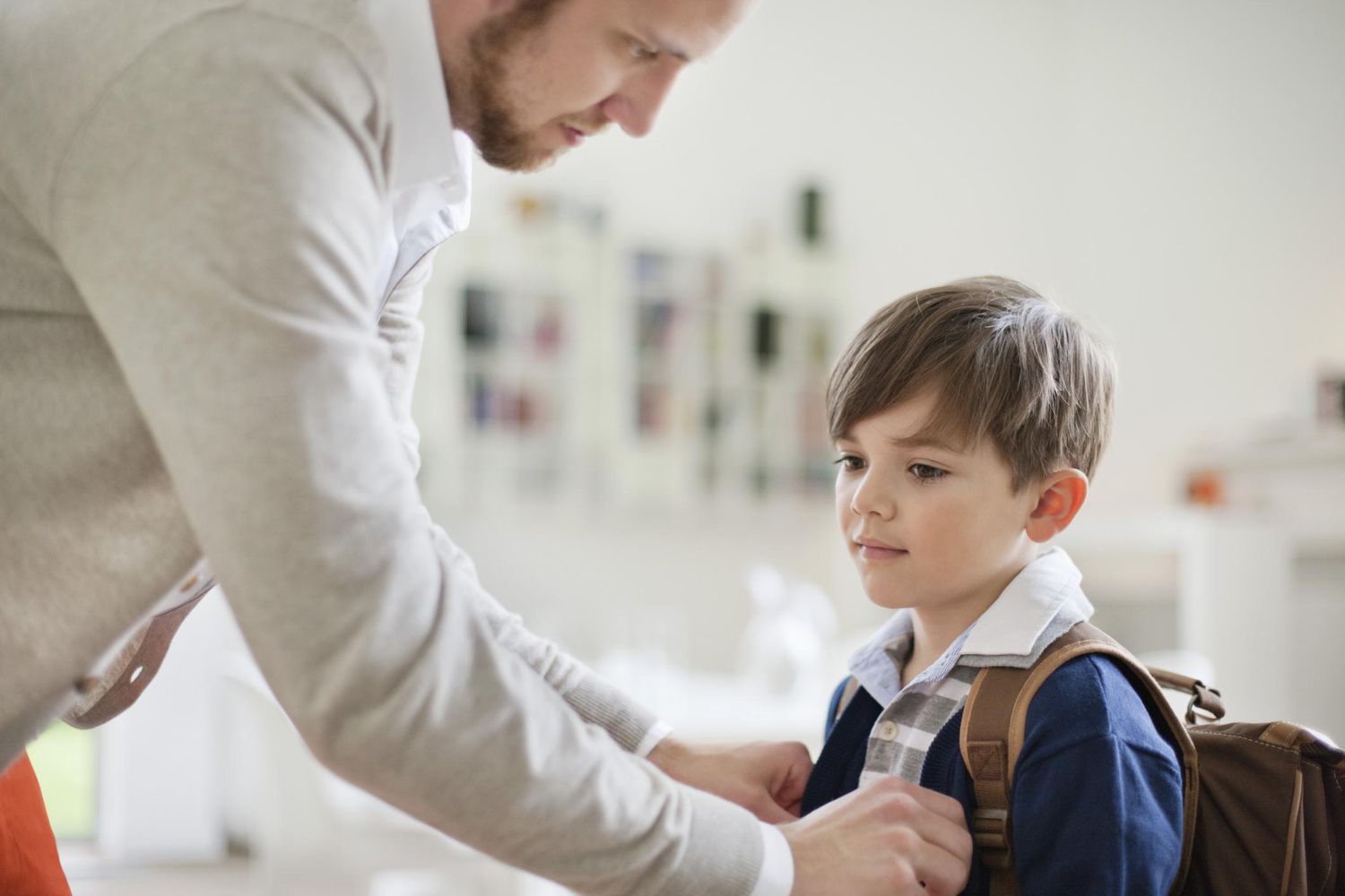 Man preparing his son for school