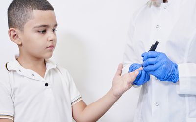 护士给一个小男孩做糖尿病检查。