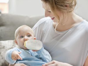 女婴用奶瓶吃奶。