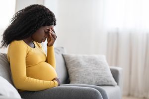 pregnant person touching forehead